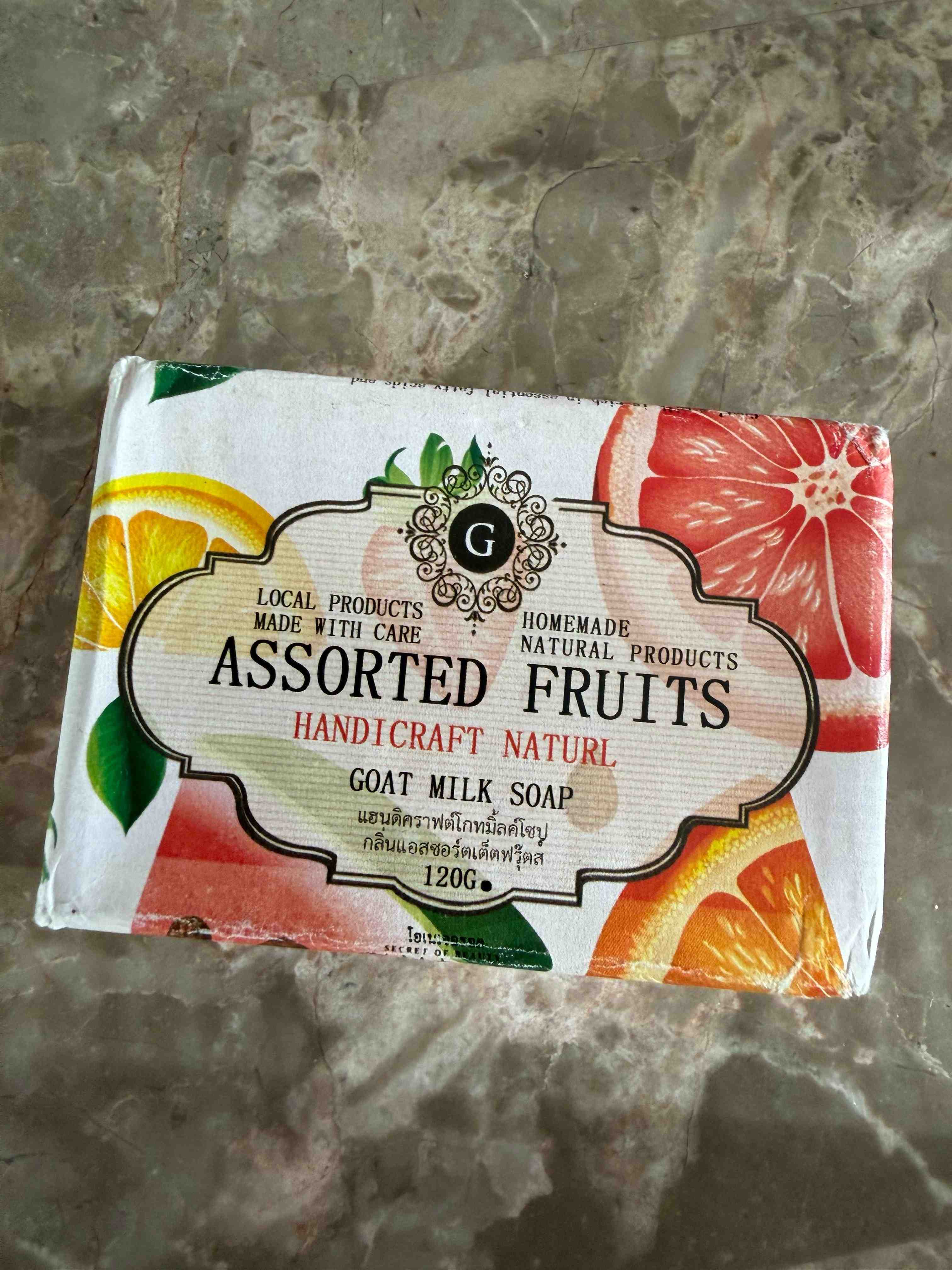 Bar of soap with 'Assorted Fruits' packaging on a textured surface