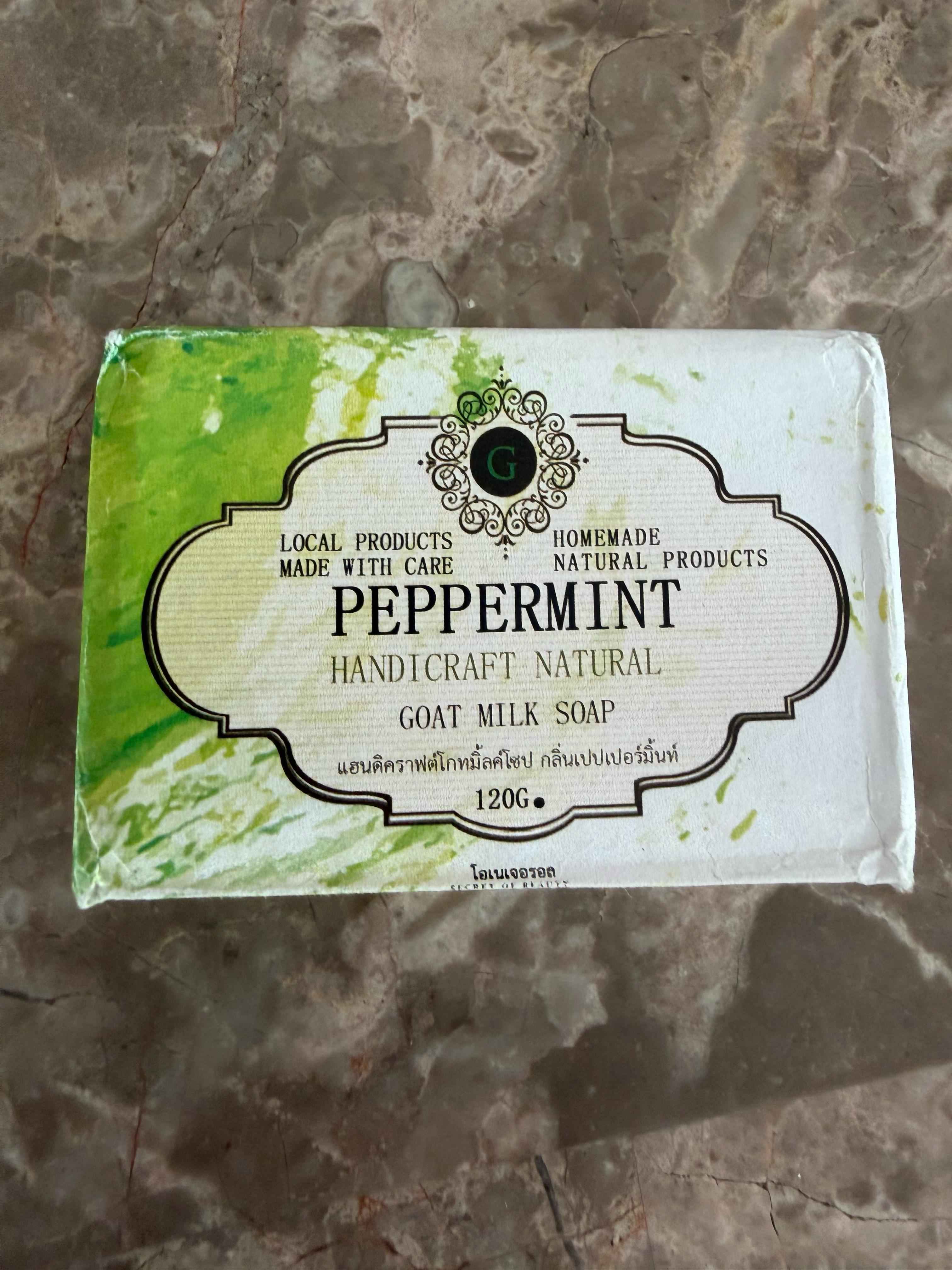 Peppermint goat milk soap bar on a textured surface